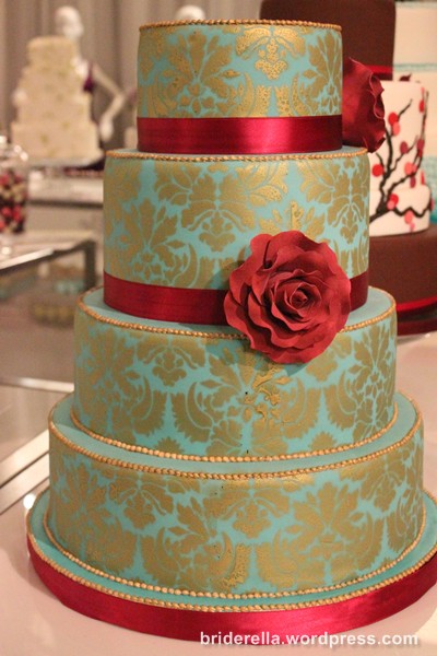 Intricate gold patterns on a teal and red wedding cake