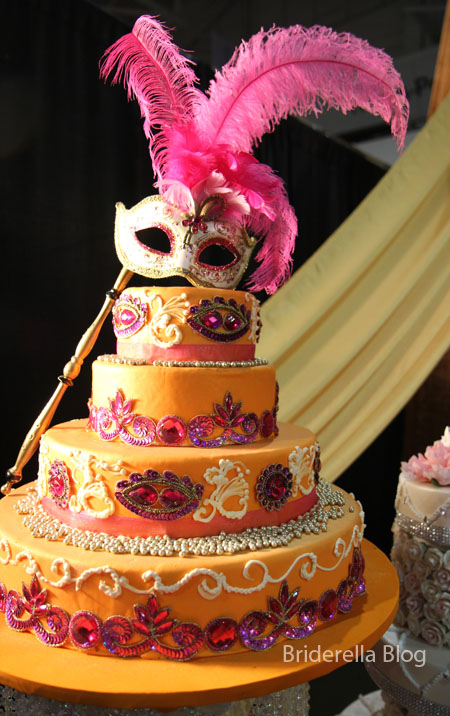 A Masquerade inspired wedding cake in orange hot pink and purple
